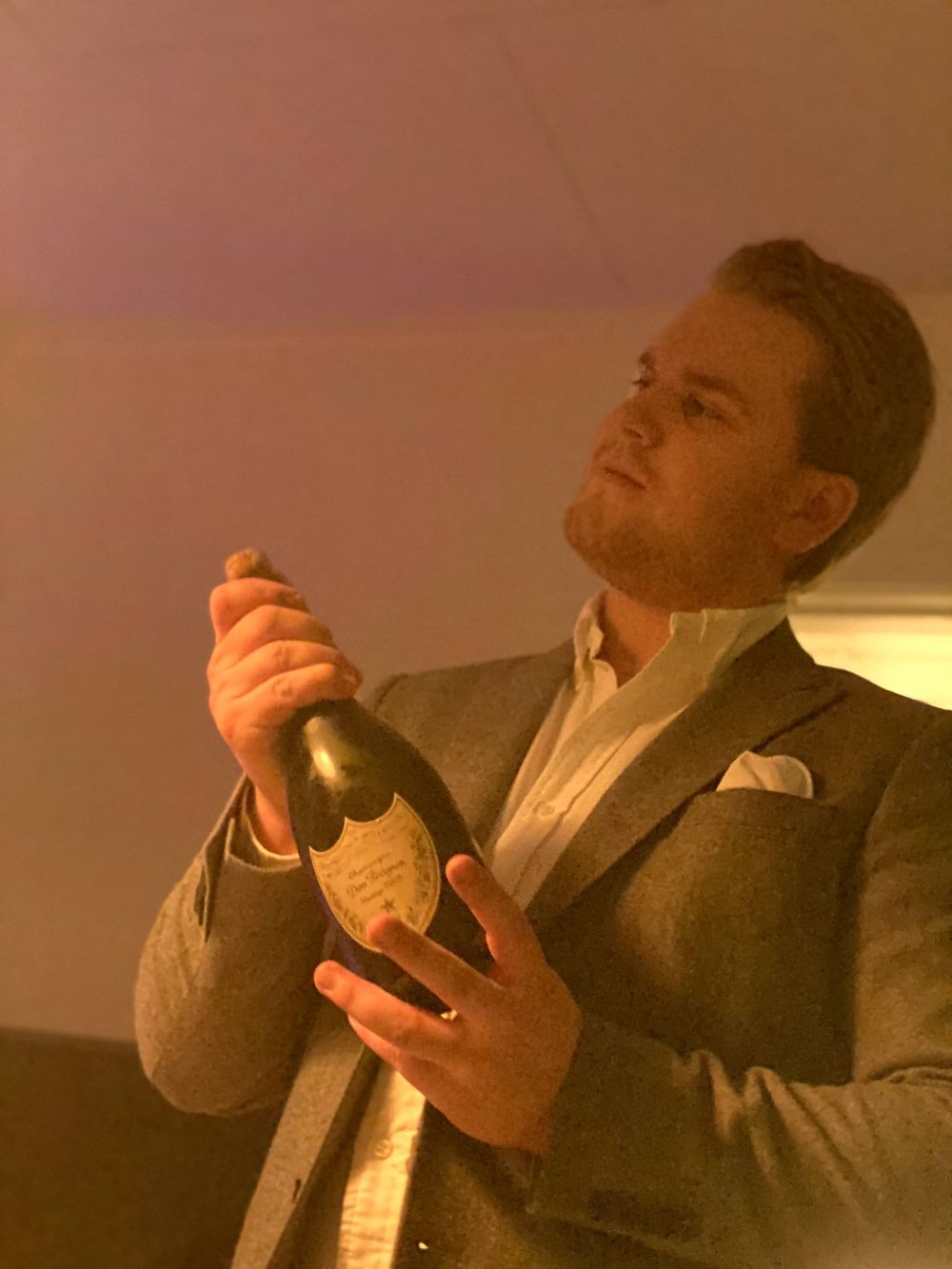 Nordnes i dress holder en champagneflaske